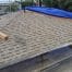 Residential roof repair with tarp and lumber
