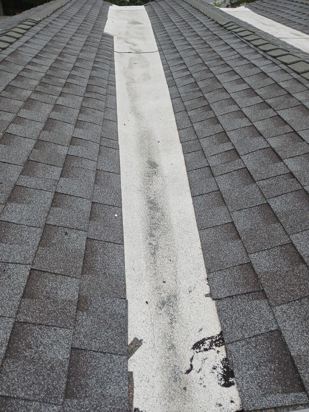 Asphalt shingle roof with white valley membrane