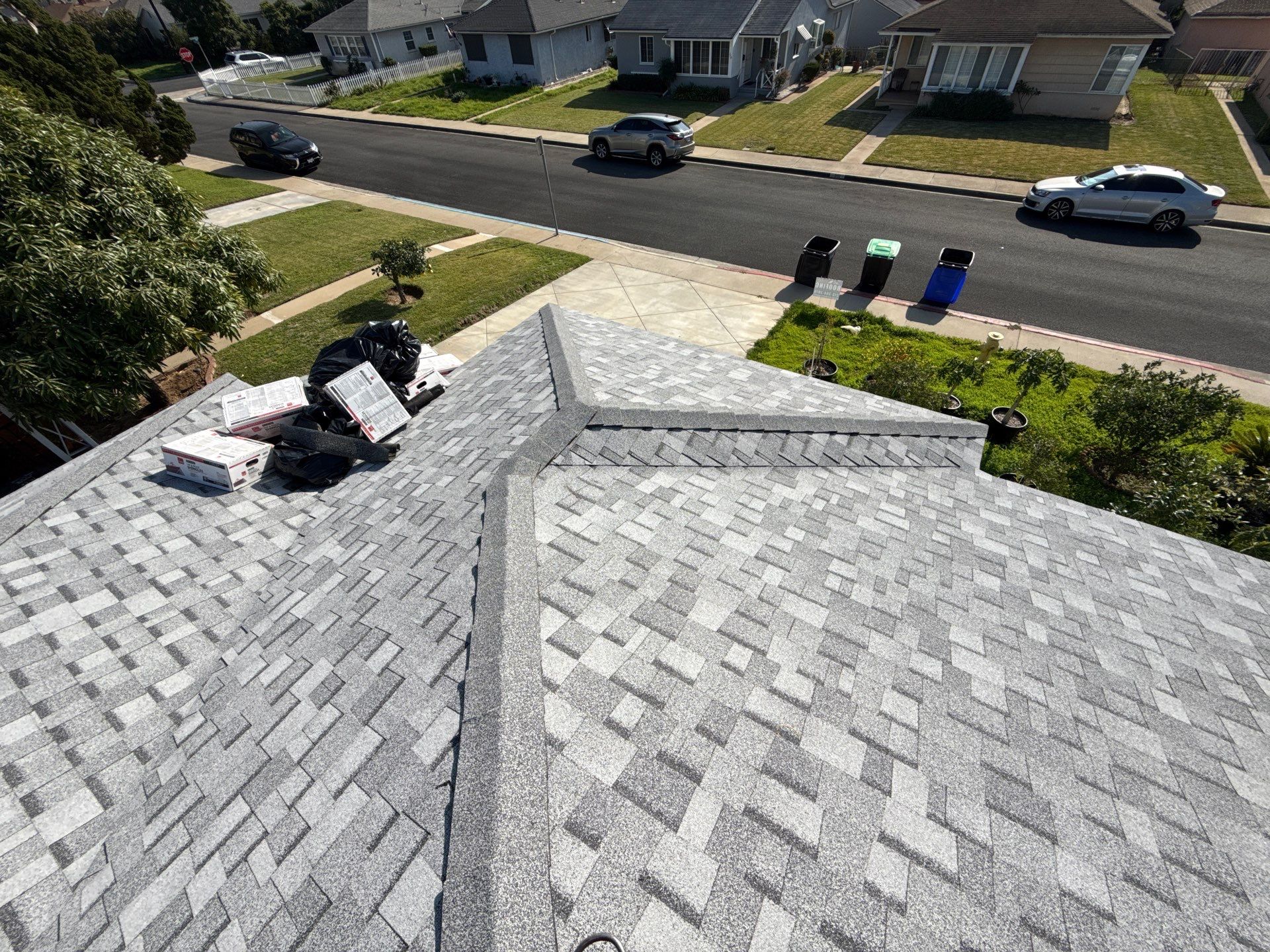 New gray shingle roof overlooking suburban street
