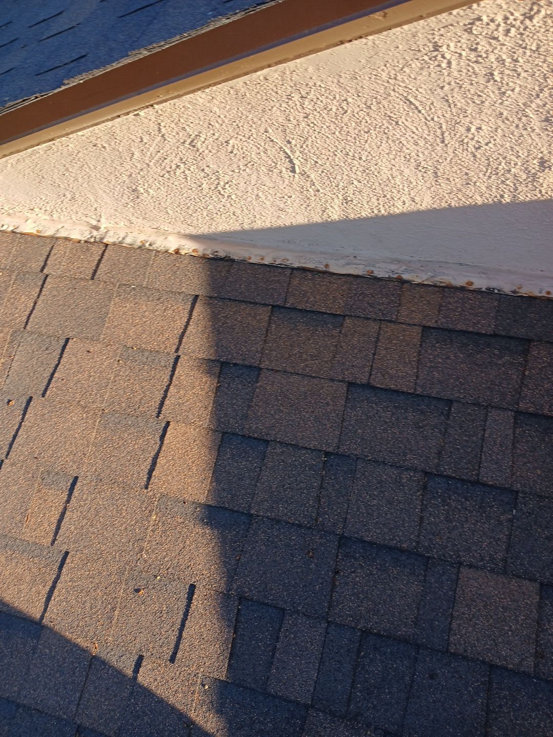 15-Mar 17 2026 08_00am-UUyK Asphalt roof shingles meeting stucco wall with flashing