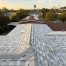 Gray shingle rooftop overlooking suburban neighborhood at sunset