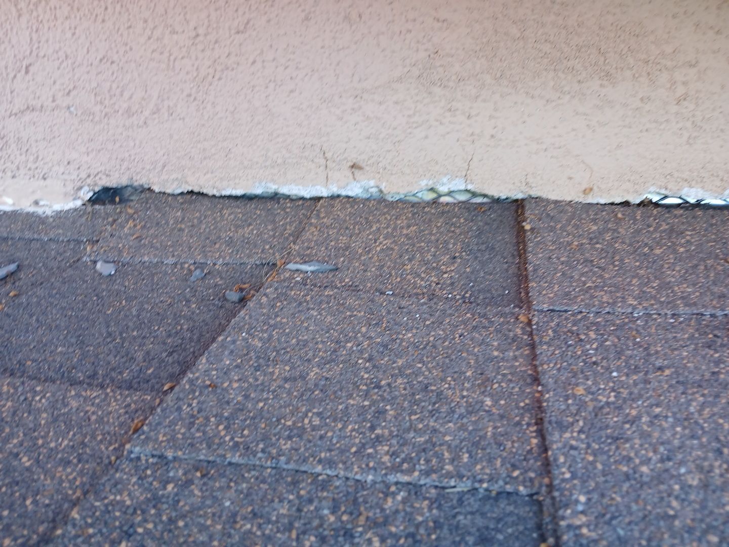 20-Mar 17 2026 08_01am-pE3U Damaged roof shingles along exterior stucco wall