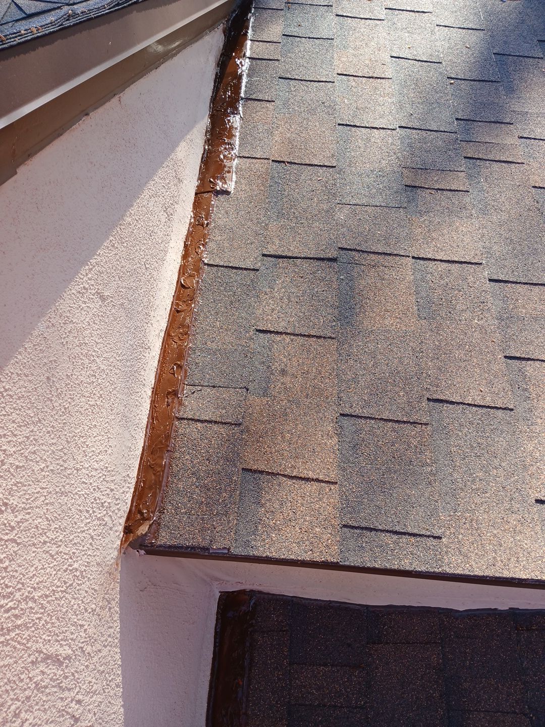 32-Mar 17 2026 08_50am-ynfL Roof shingles with sealant along wall flashing