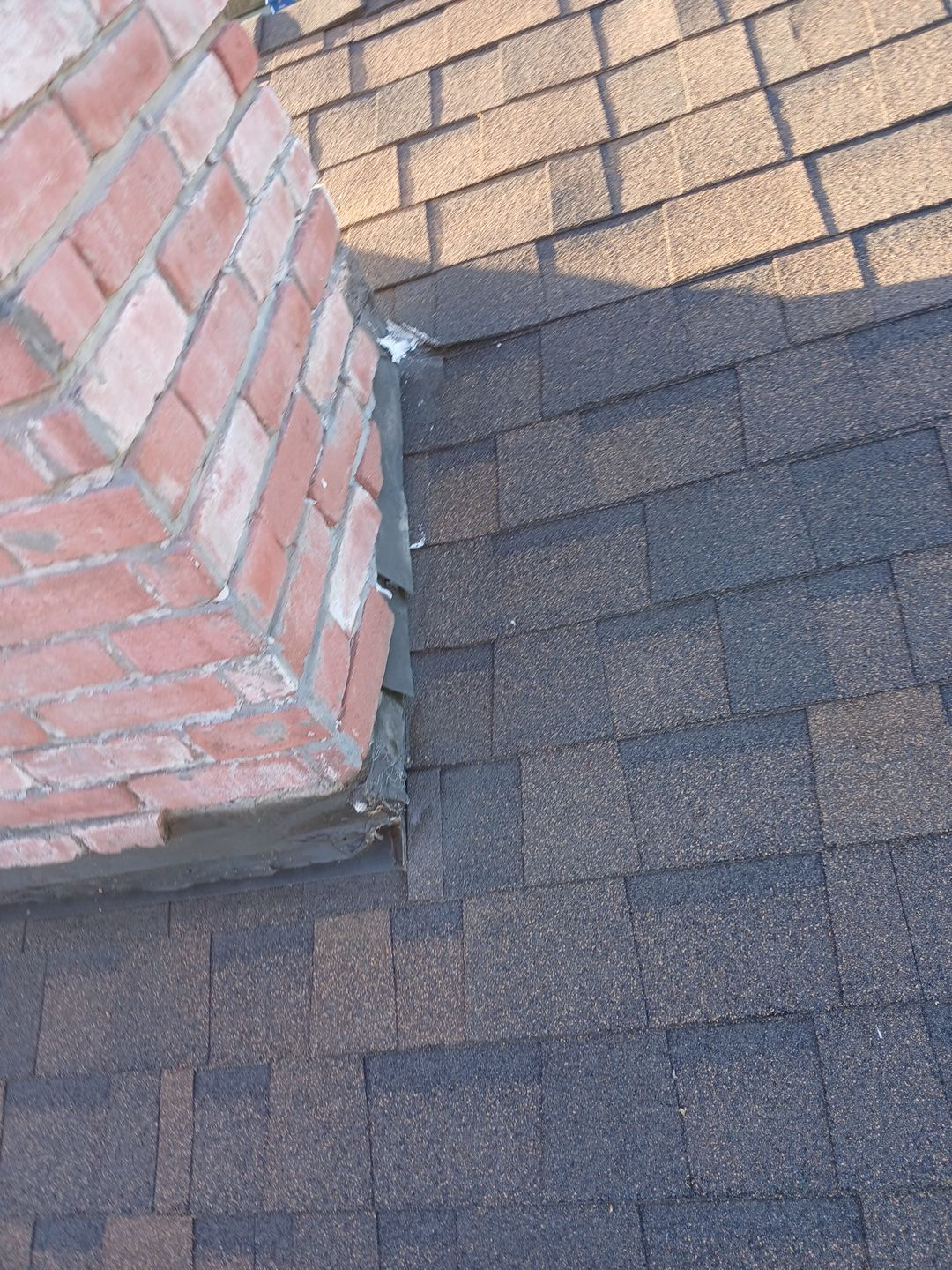 4-Mar 17 2026 07_59am-KwwT Asphalt shingle roof meeting brick chimney flashing