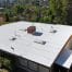 Flat white residential roof with chimney and vents