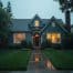 Cozy suburban house glowing at dusk in rain