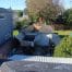 Worker removing shingles from residential garage roof