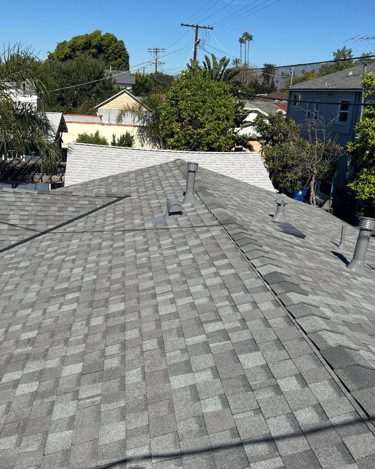 New gray asphalt shingle roof with plumbing vents and roof jacks on a residential home in Southern California.