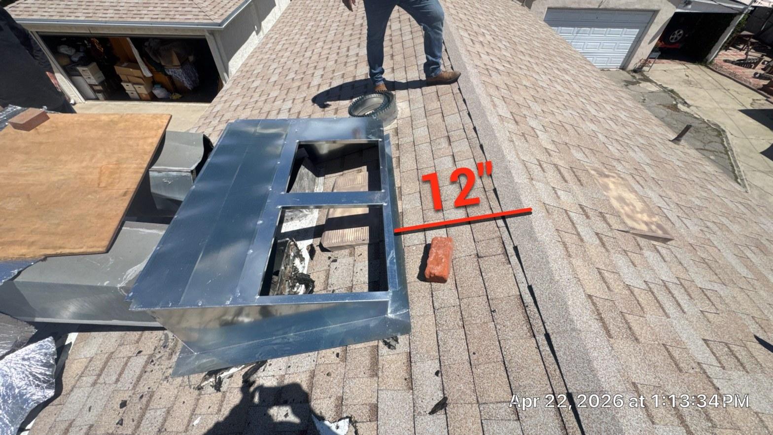 carrier-rooftop-package-unit-installation-burbank-ca-819 Sheet metal skylight curb frame installed on asphalt shingle roof with 12-inch clearance marked in red, brick and worker visible.