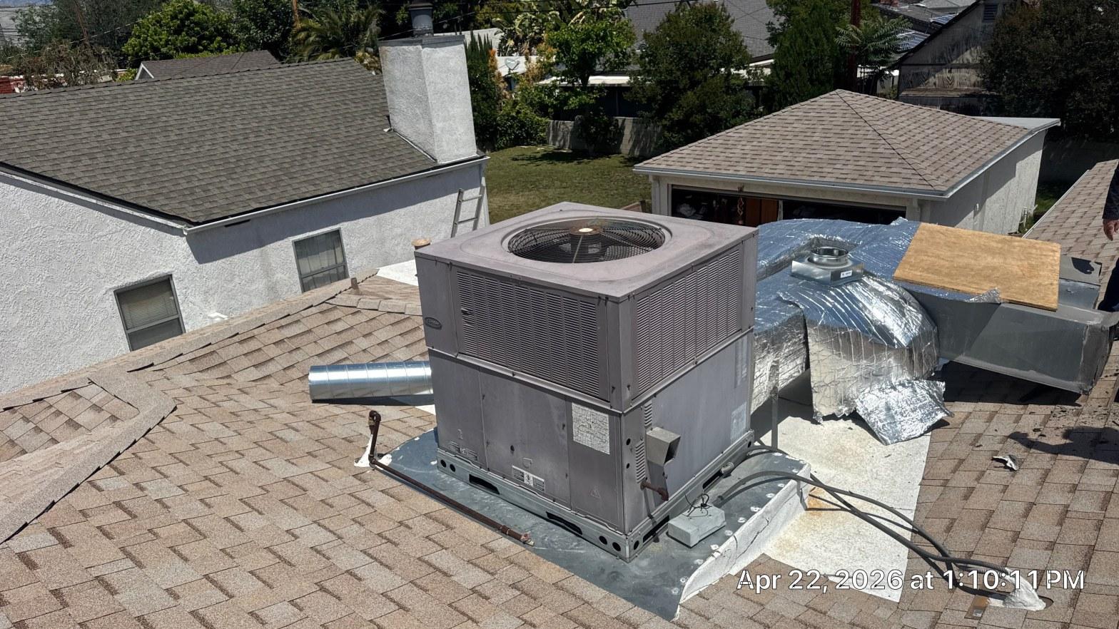 carrier-rooftop-package-unit-installation-burbank-ca-822 Carrier rooftop package AC unit on curb mount with flex ductwork and round supply duct on residential shingle roof.