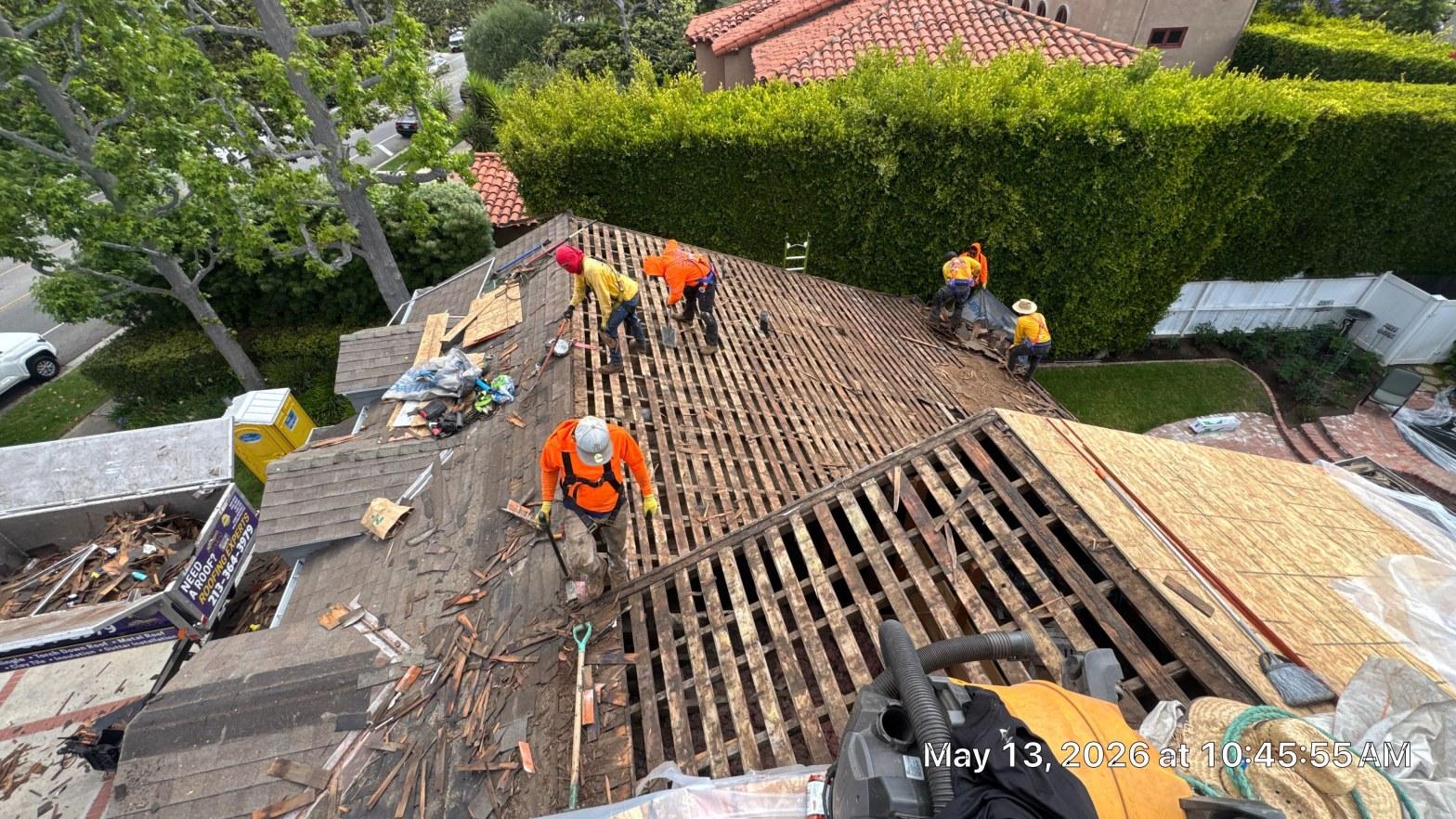 shingle-reroof-motor-ave-los-angeles-619 Roofing crew removing old wood lath and tile from residential roof, exposing bare rafters, Los Angeles area.