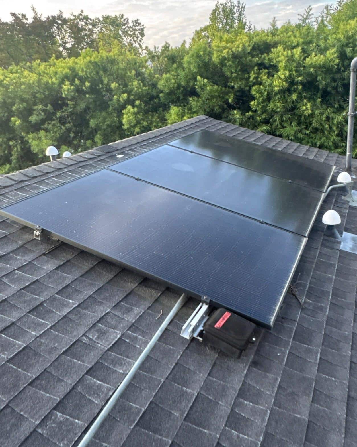shingle-reroof-solar-complex-flashing-los-angeles-652 Six black monocrystalline solar panels installed on gray asphalt shingle roof with microinverter visible below array.