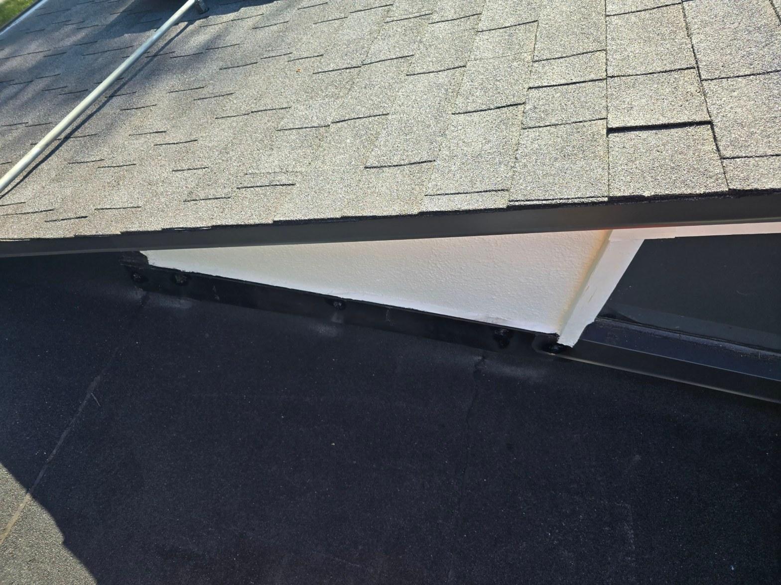 shingle-reroof-solar-complex-flashing-los-angeles-655 Junction of flat EPDM rubber roof and pitched asphalt shingle roof with dark metal drip edge and white fascia board.