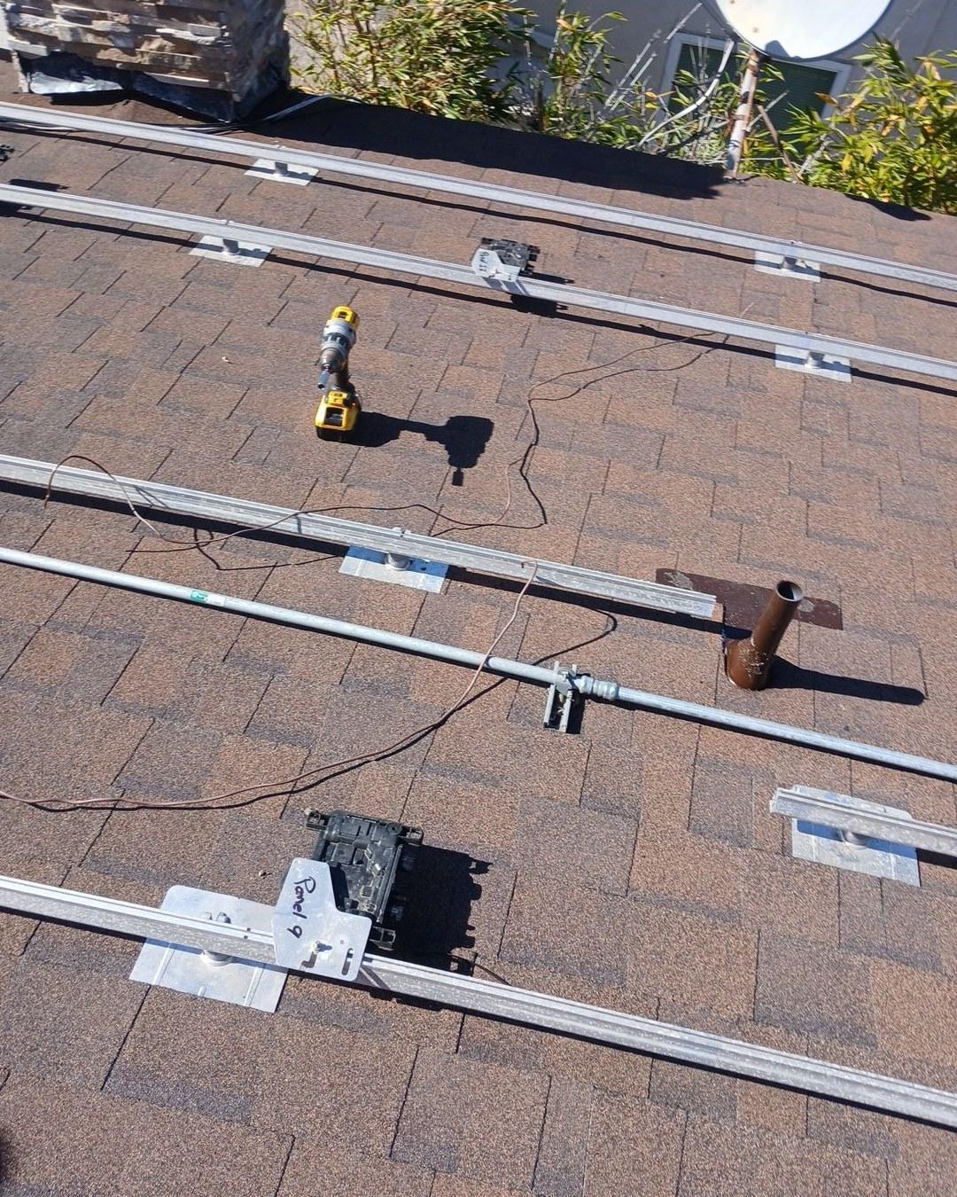 Aluminum solar panel mounting rails and flashed brackets installed on new brown asphalt shingle roof in Redondo Beach CA