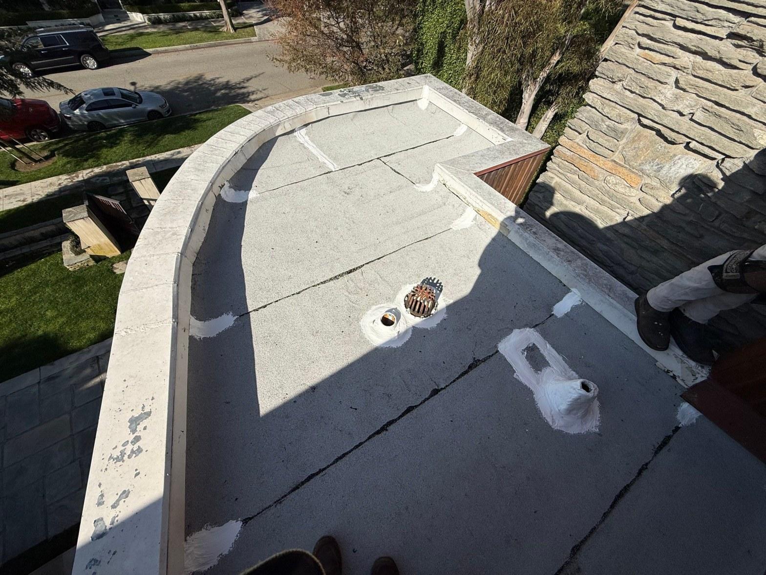 Flat roof with two drains sealed with white elastomeric coating, Beverly Hills torch-down roof repair