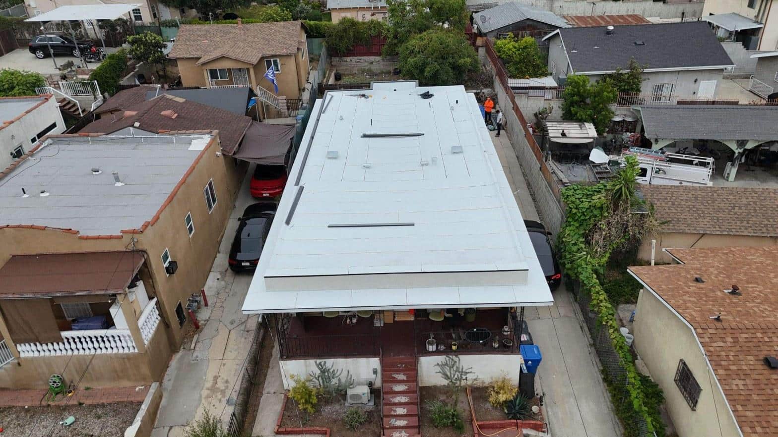 Aerial view of white torch-down modified bitumen flat roof installed on single-story residential building at 2816 Johnston St, Los Angeles