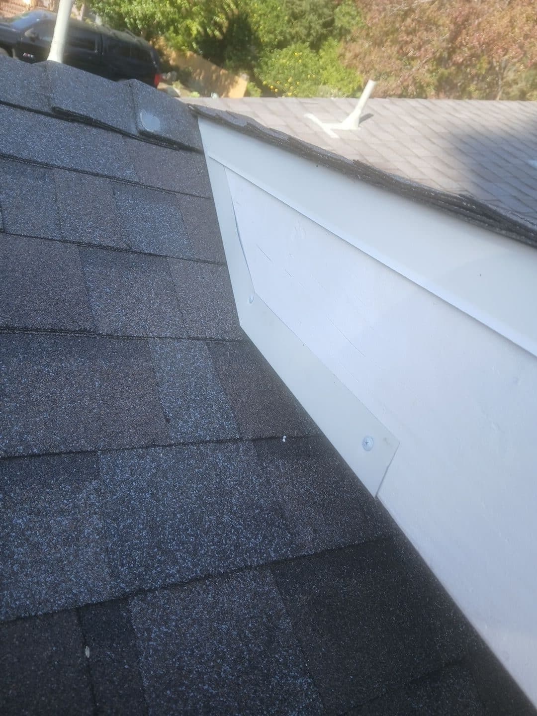 Dark asphalt shingles meeting white fascia board at roof edge | Roof Replacement Inc Dark asphalt shingles meeting white fascia board at roof edge — Roof Replacement Inc