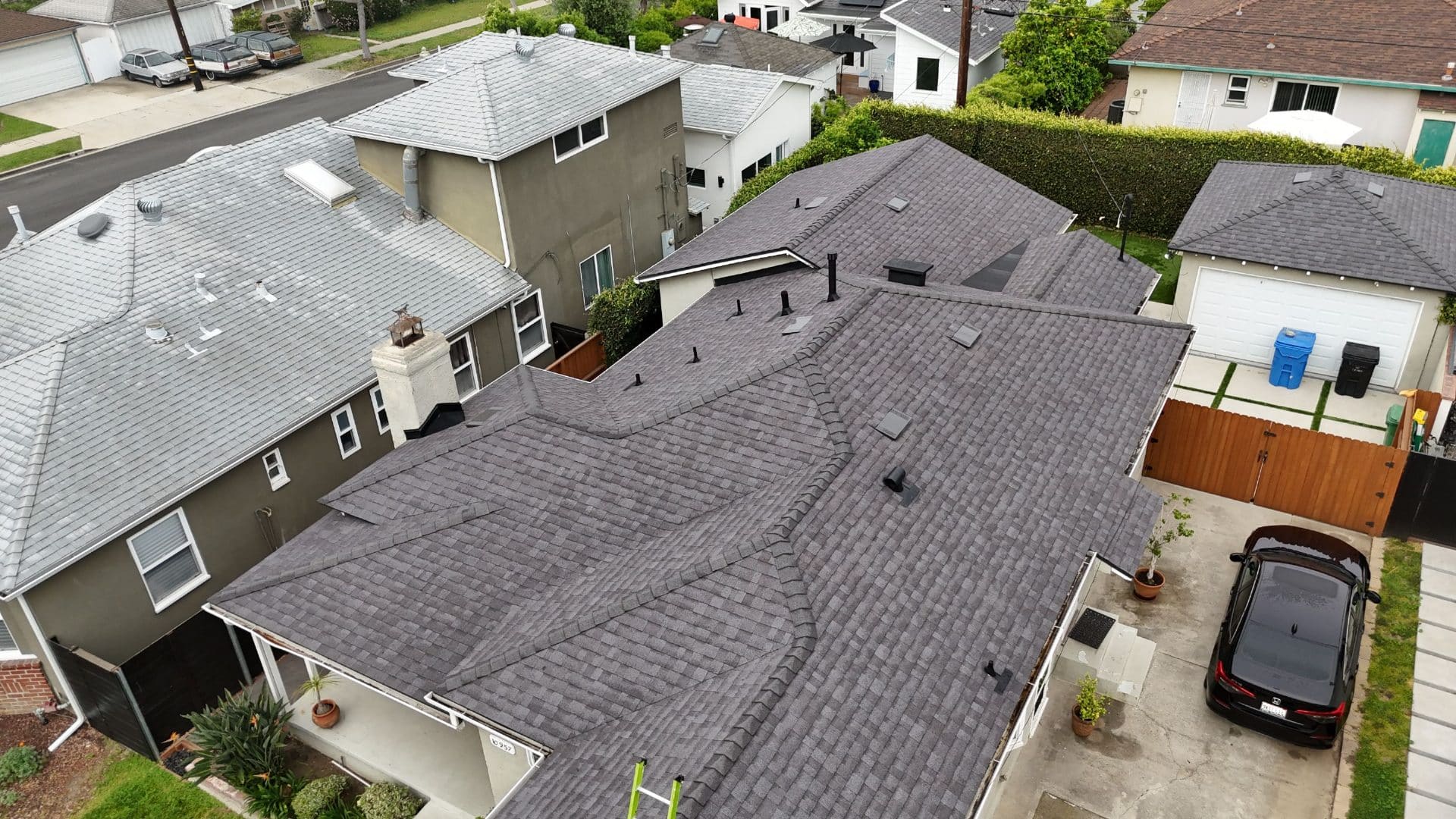 Aerial view of completed dark gray asphalt shingle hip roof with vents — Roof Replacement Inc