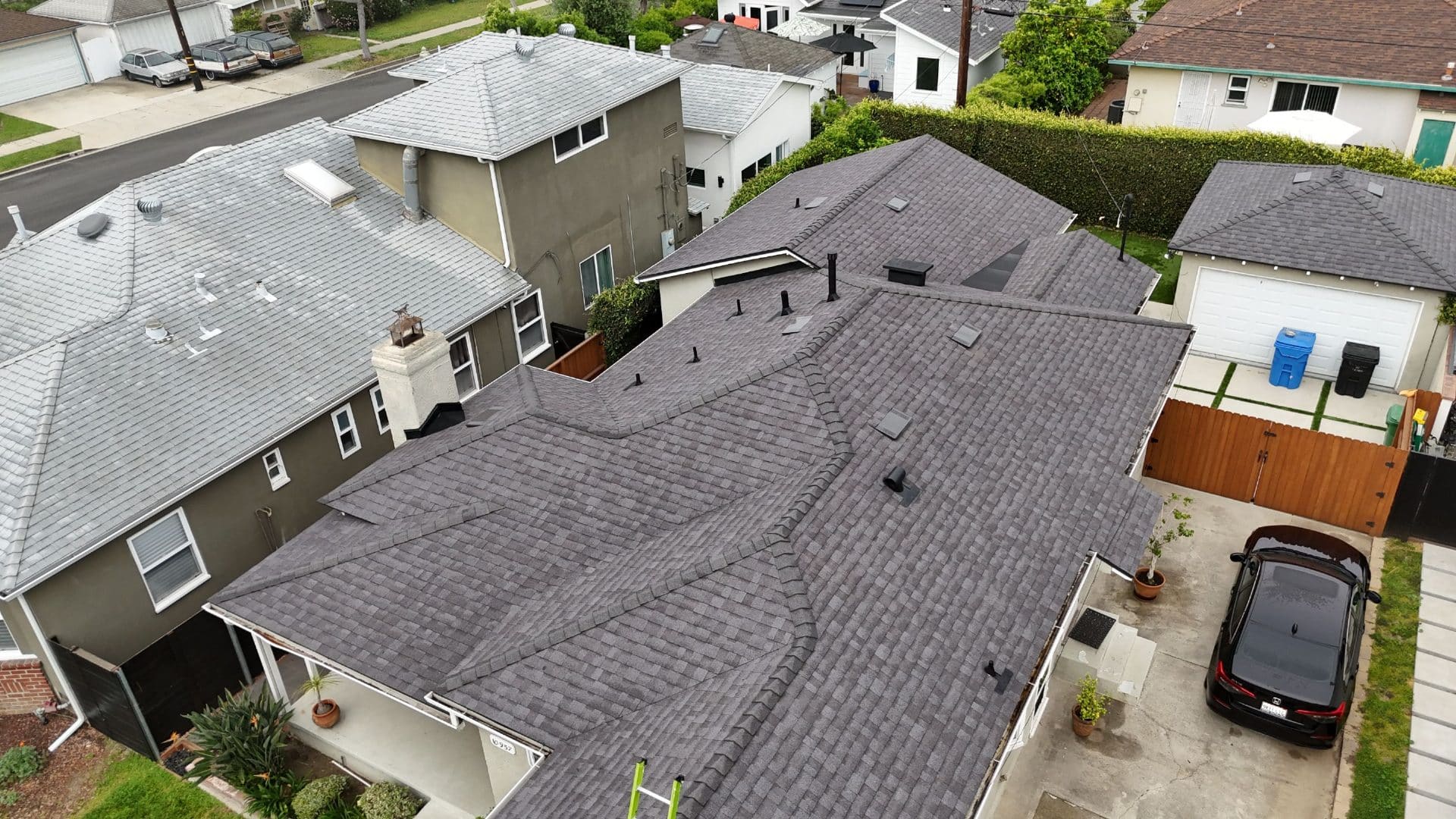 Aerial view of completed dark grey asphalt shingle roof with multiple valleys and vents — Roof Replacement Inc