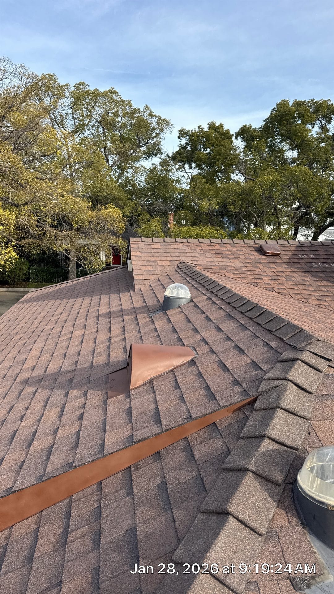 Brown asphalt shingle roof with copper flashing, dome skylights, ridge vents — Roof Replacement Inc