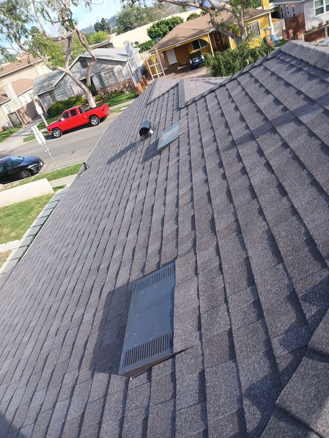 New dark grey asphalt shingle roof with two flat vents and pipe vent | Roof Replacement Inc New dark grey asphalt shingle roof with two flat vents and pipe vent — Roof Replacement Inc