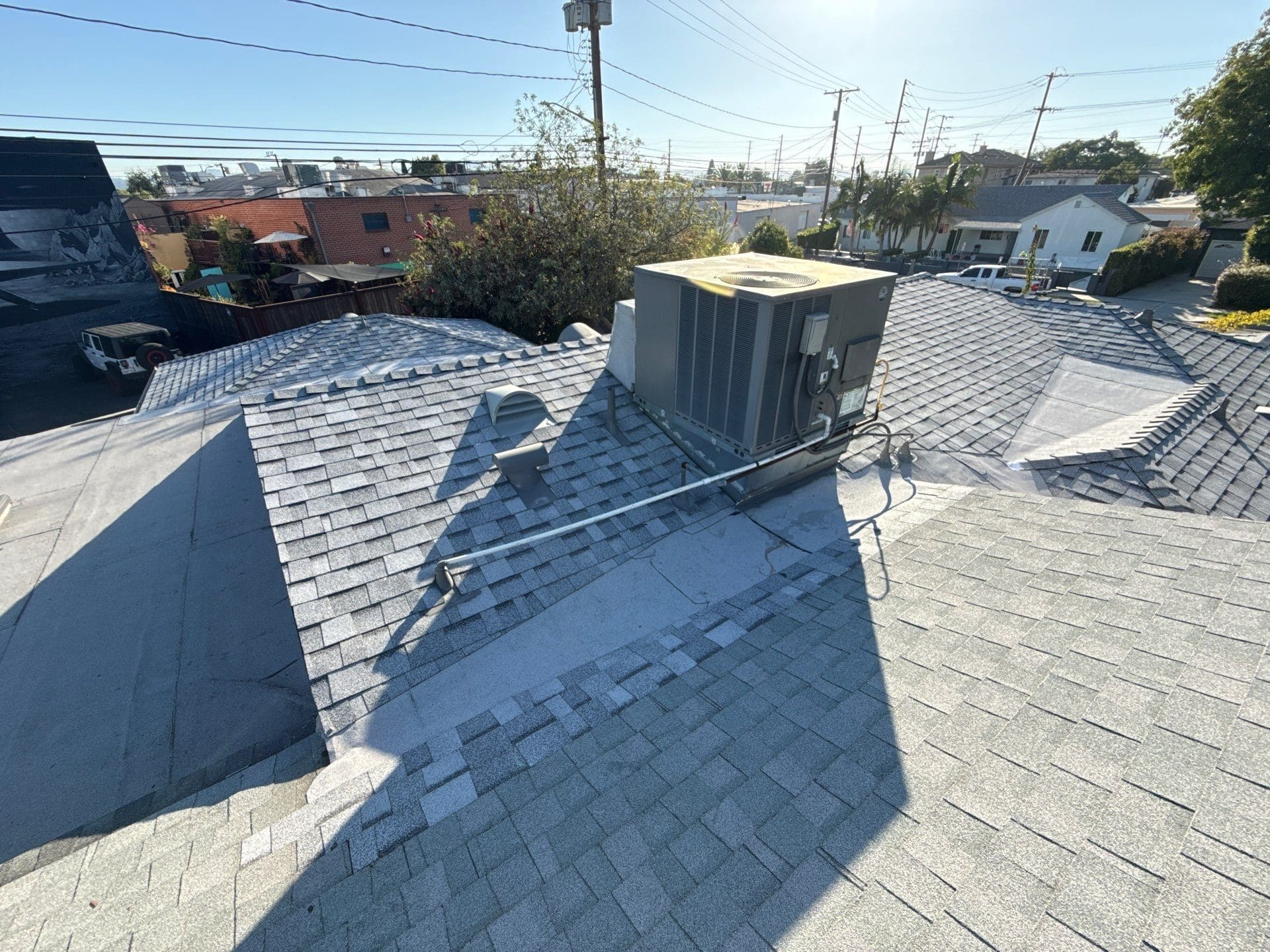 Gray asphalt shingle roof with rooftop HVAC unit installed | Roof Replacement Inc Gray asphalt shingle roof with rooftop HVAC unit installed — Roof Replacement Inc
