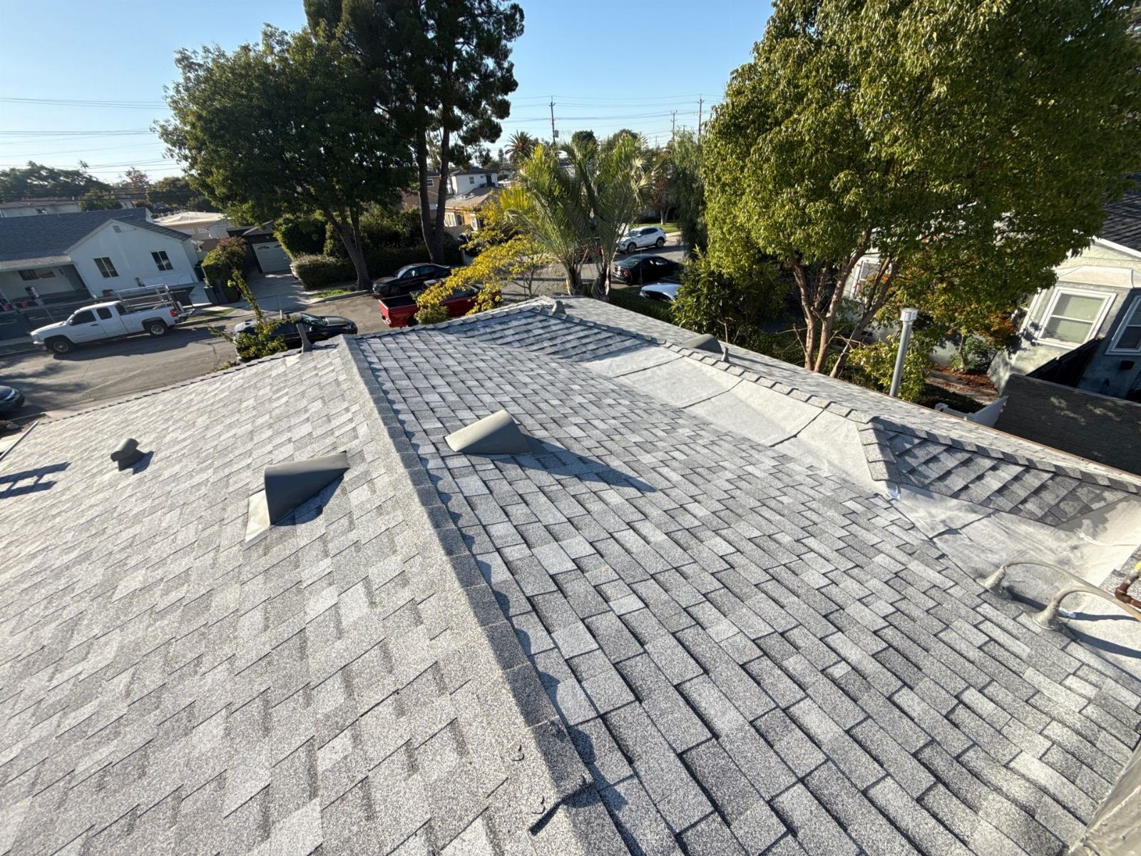 Gray asphalt shingle roof mid-installation with open underlayment sections | Roof Replacement Inc Gray asphalt shingle roof mid-installation with open underlayment sections — Roof Replacement Inc