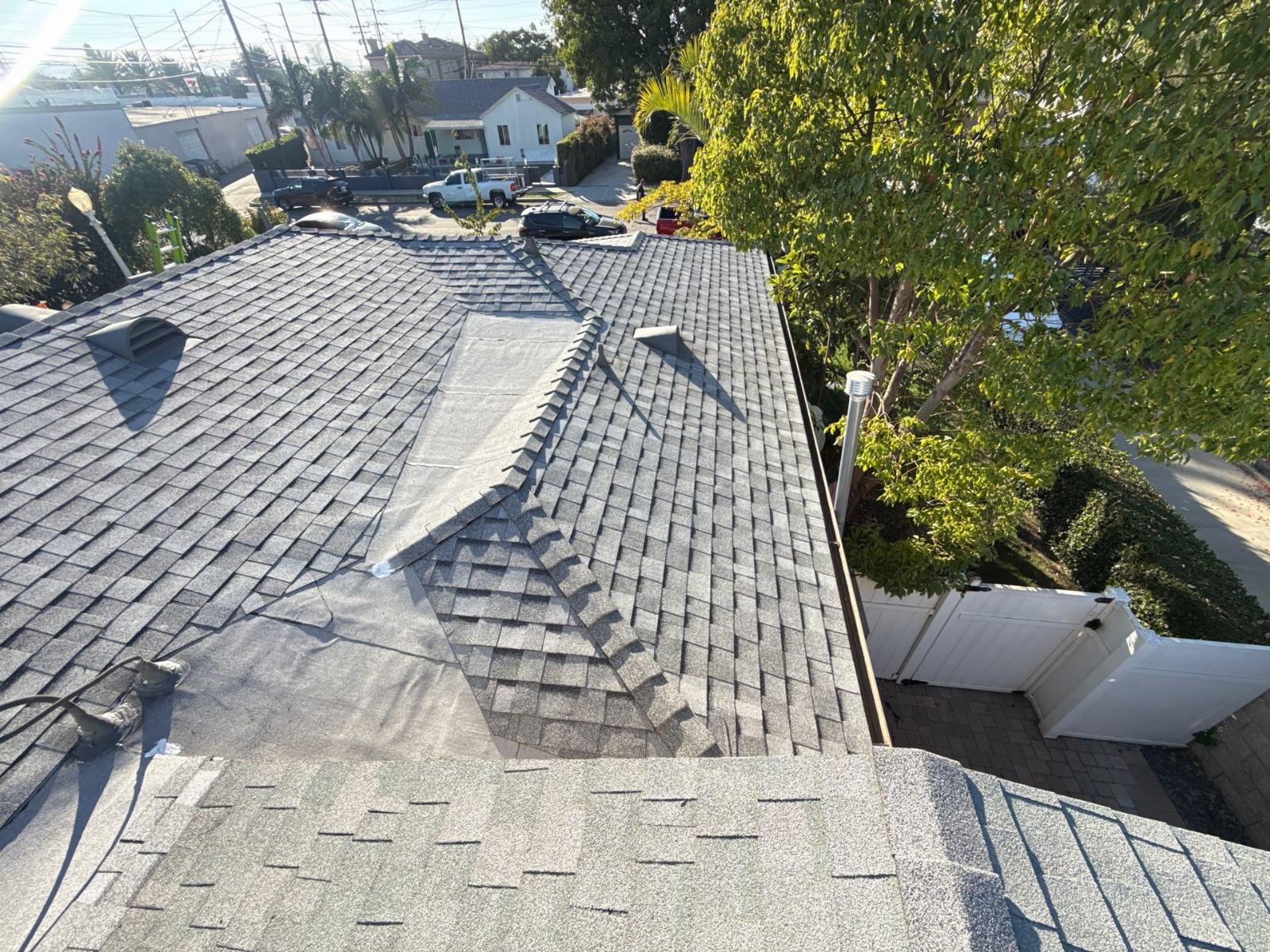 gray asphalt shingle roof mid-installation with underlayment exposed — Roof Replacement Inc