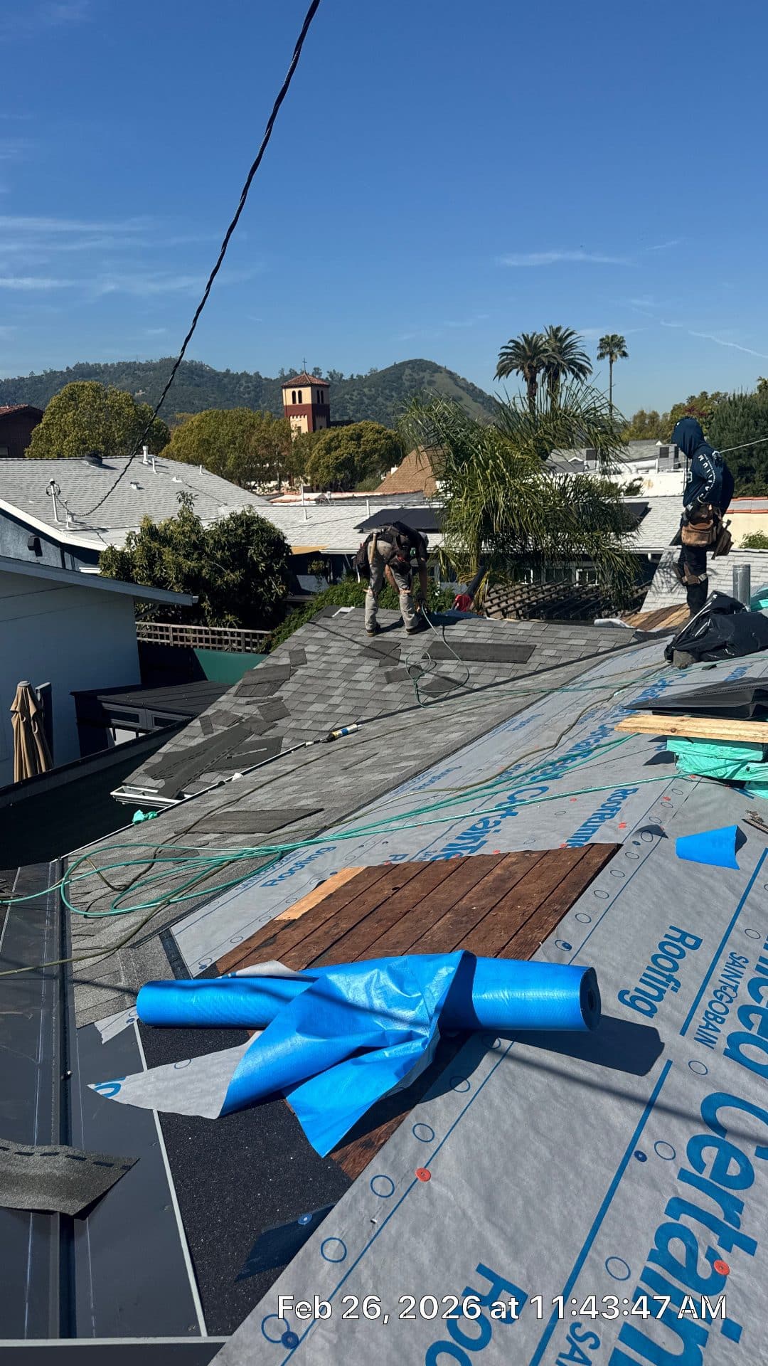 Roofers installing asphalt shingles over underlayment on residential roof | Roof Replacement Inc Roofers installing asphalt shingles over underlayment on residential roof — Roof Replacement Inc