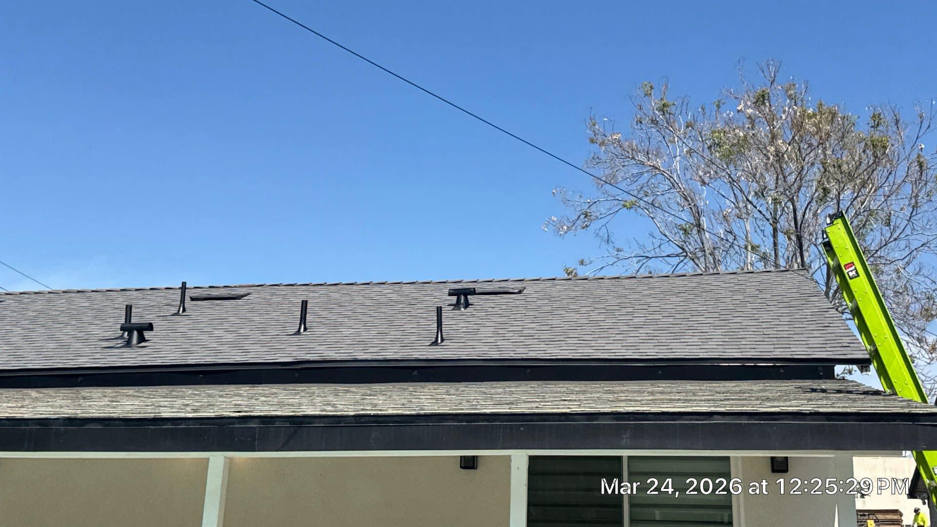 Gray asphalt shingle roof with pipe boots, drip edge, green ladder | Roof Replacement Inc Gray asphalt shingle roof with pipe boots, drip edge, green ladder — Roof Replacement Inc