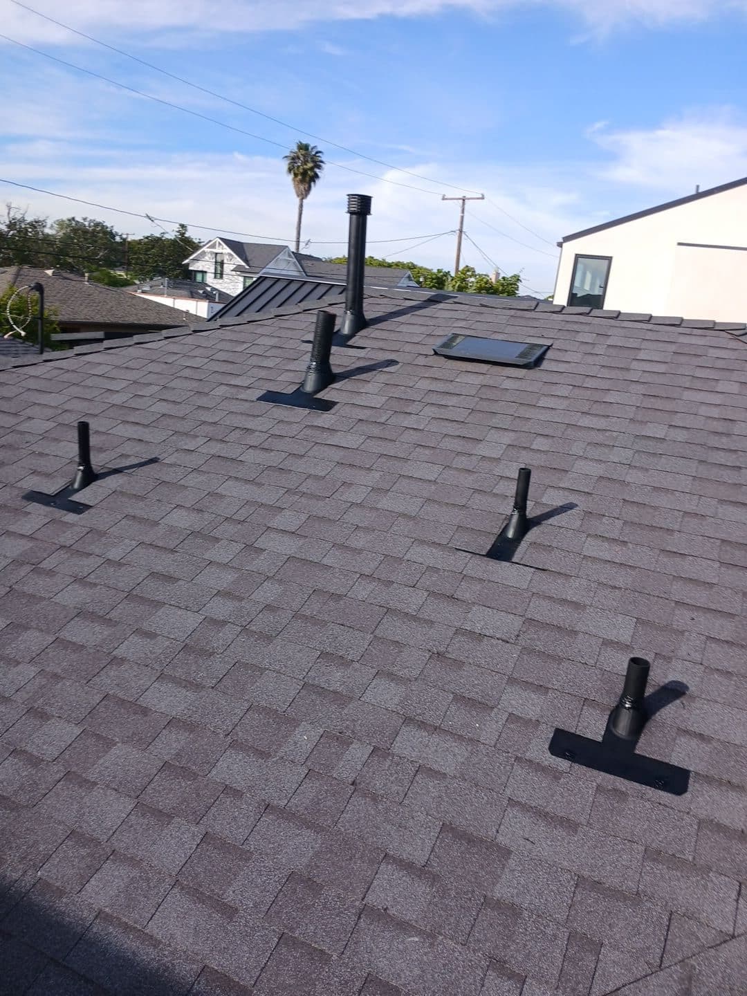 New asphalt shingle roof with multiple black pipe boots and skylight | Roof Replacement Inc New asphalt shingle roof with multiple black pipe boots and skylight — Roof Replacement Inc