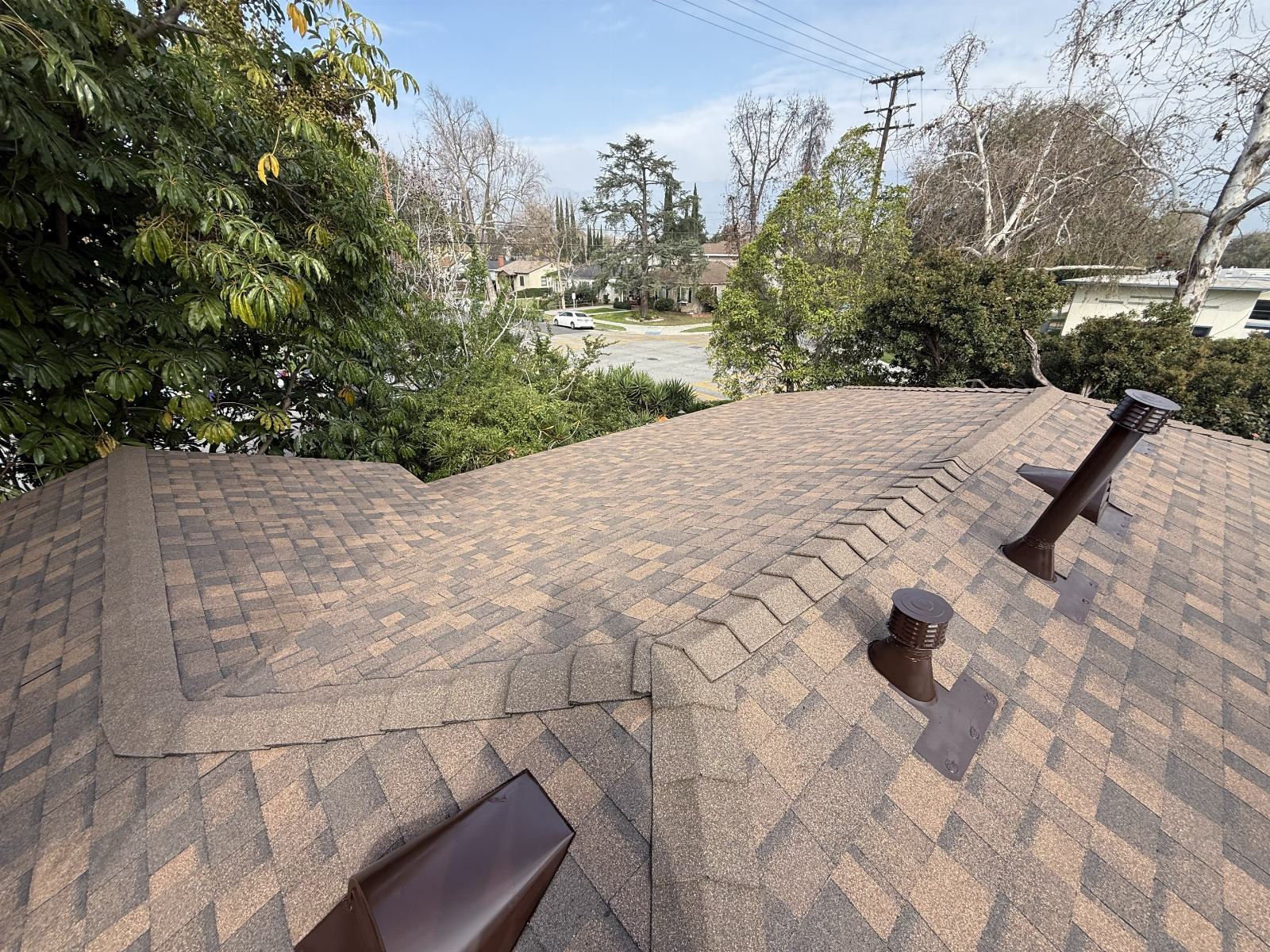 Asphalt shingle roof with brown pipe vents and valley flashing in Burbank | Roof Replacement Inc asphalt shingle roof with brown pipe vents and valley flashing — Burbank — Roof Replacement Inc