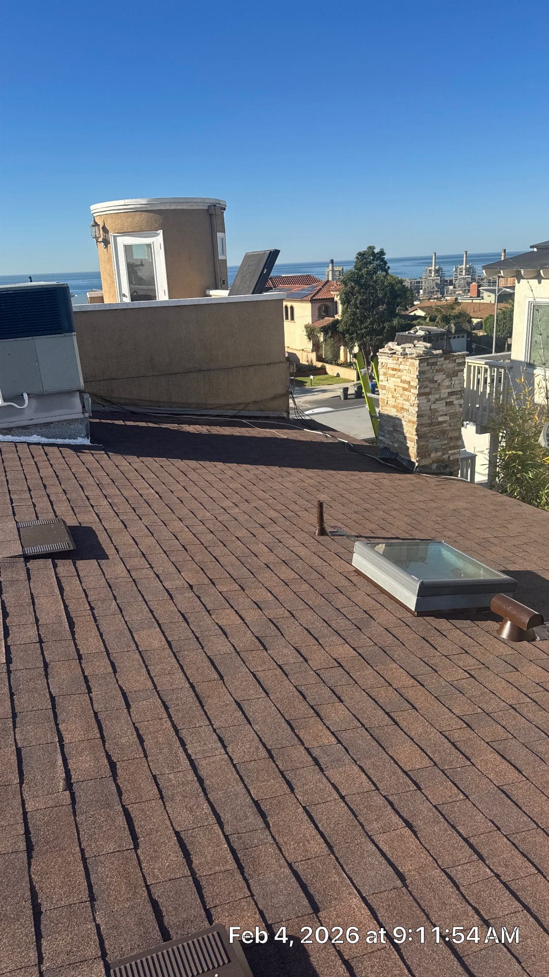 Asphalt shingle roof with skylight, vents, and flat-roof parapet — Roof Replacement Inc