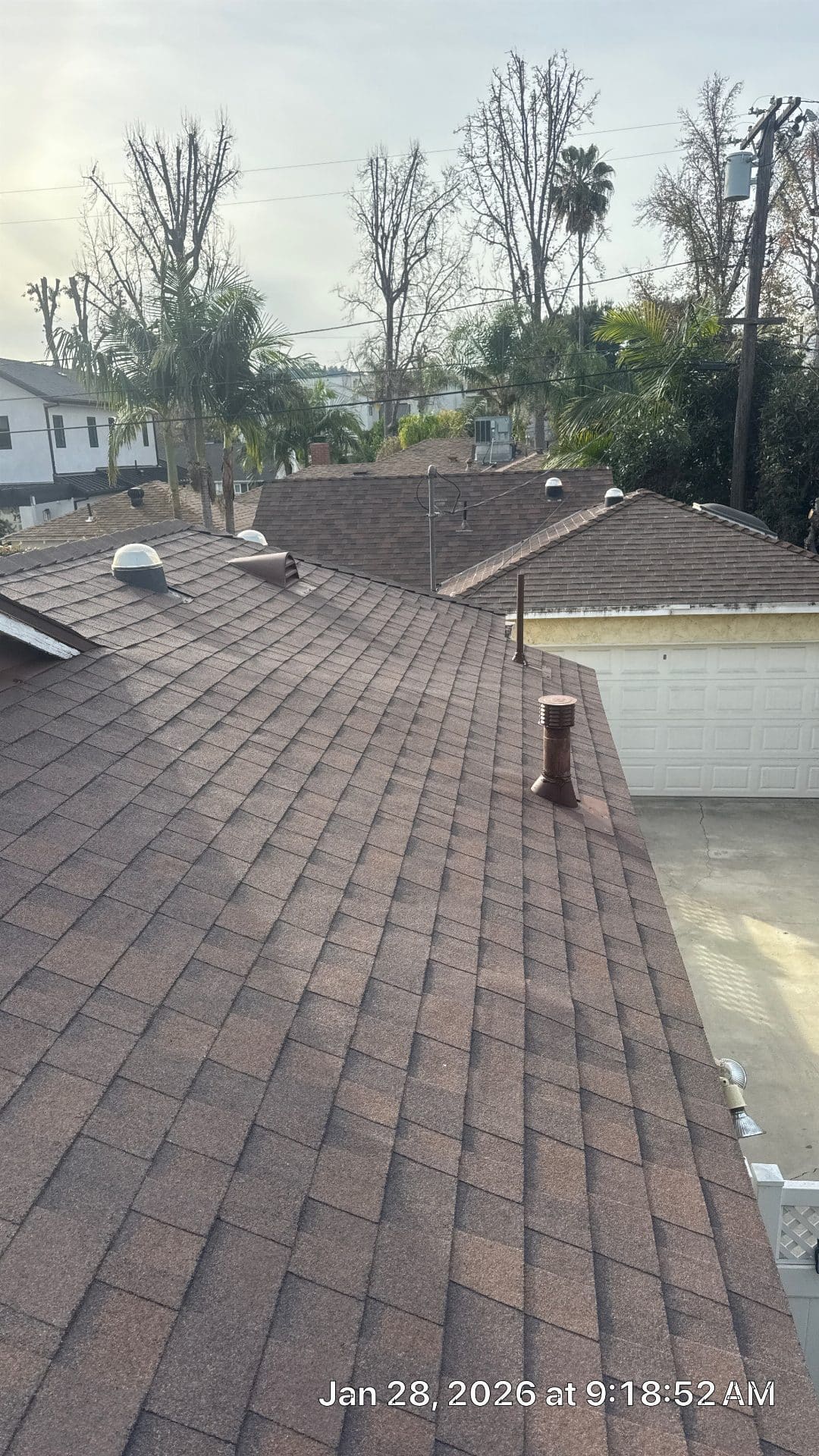 Completed brown asphalt shingle roof with pipe vents and skylights | Roof Replacement Inc Completed brown asphalt shingle roof with pipe vents and skylights — Roof Replacement Inc