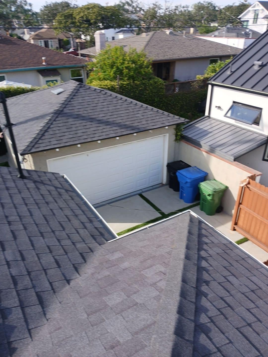 Gray asphalt shingle roofs on garage and adjacent homes, aerial view | Roof Replacement Inc Gray asphalt shingle roofs on garage and adjacent homes, aerial view — Roof Replacement Inc