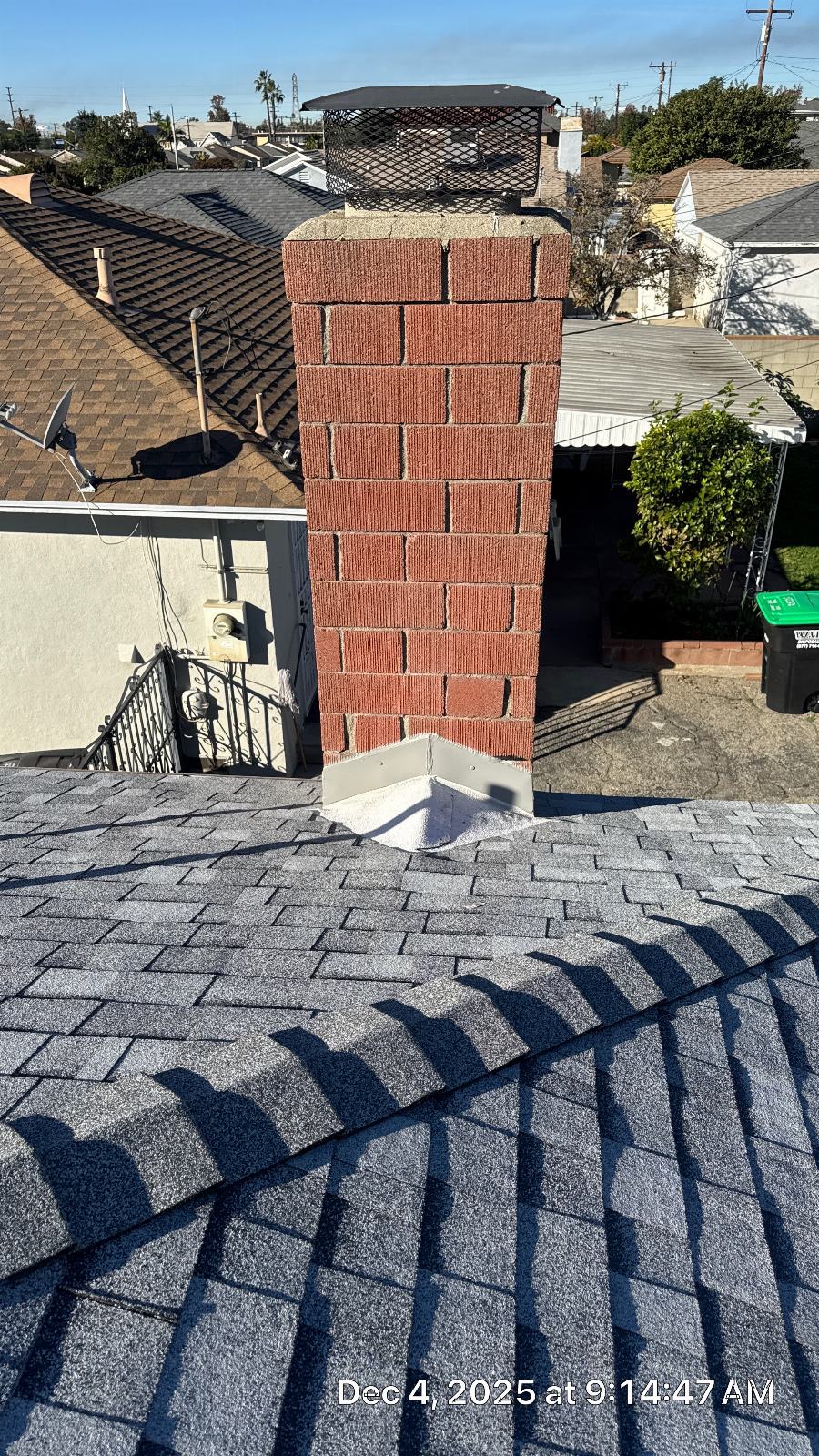 Brick chimney with cap and new metal flashing on asphalt shingle roof | Roof Replacement Inc Brick chimney with cap and new metal flashing on asphalt shingle roof — Roof Replacement Inc