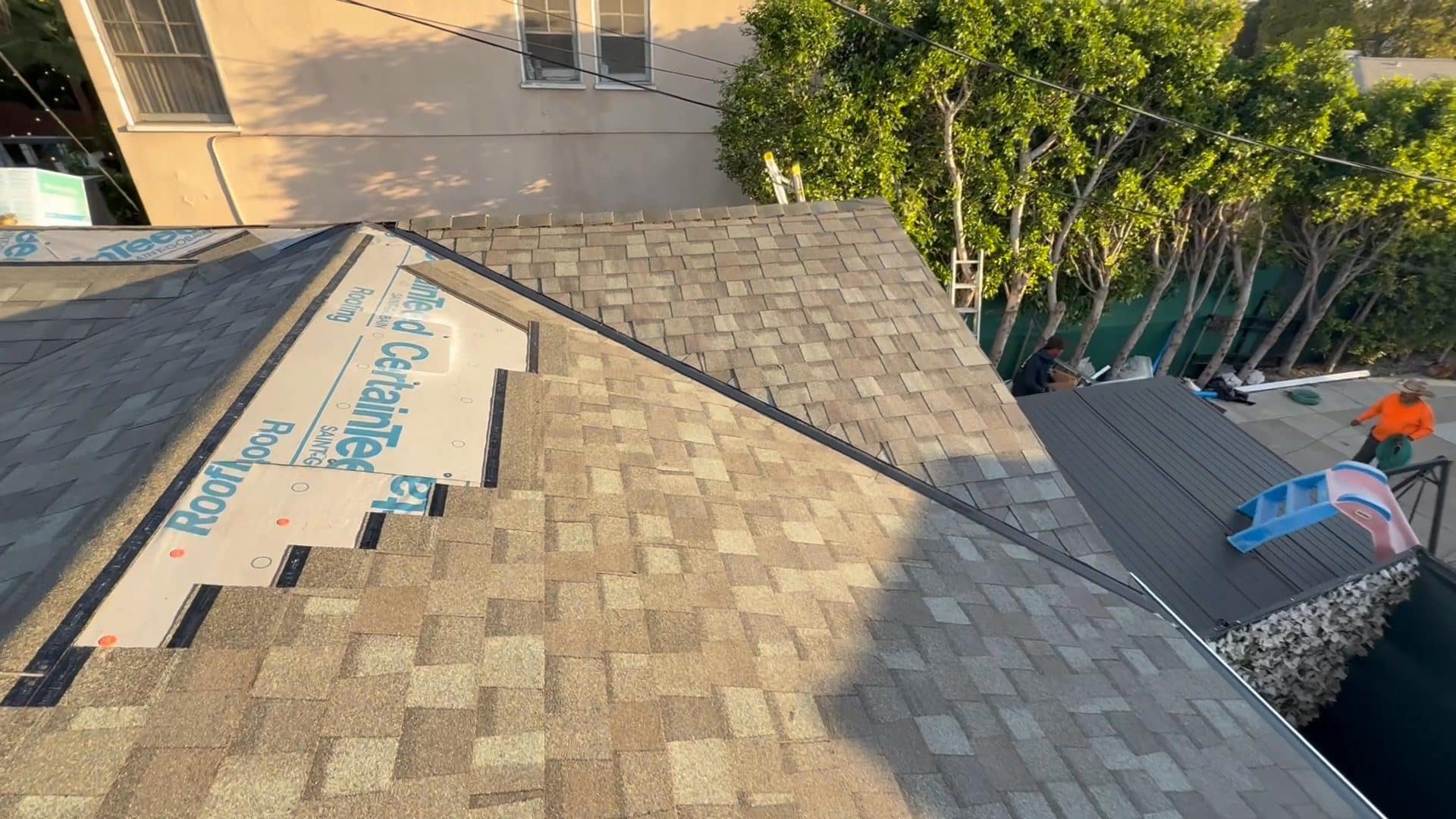 CertainTeed underlayment installed on asphalt shingle roof, workers visible — Roof Replacement Inc