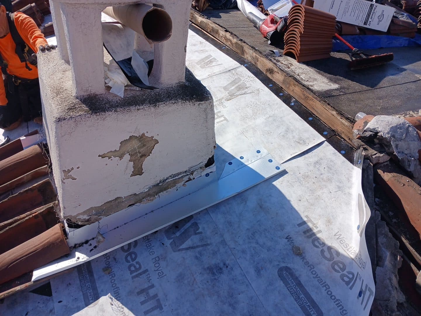 Chimney base with new galvanized flashing and TileSeal HT underlayment installed — Roof Replacement Inc