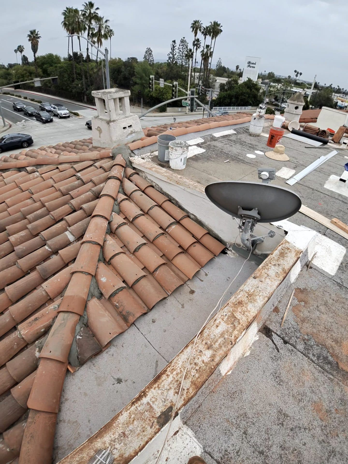 Clay barrel tile roof with flat section, chimney, satellite dish, roofing materials — Roof Replacement Inc