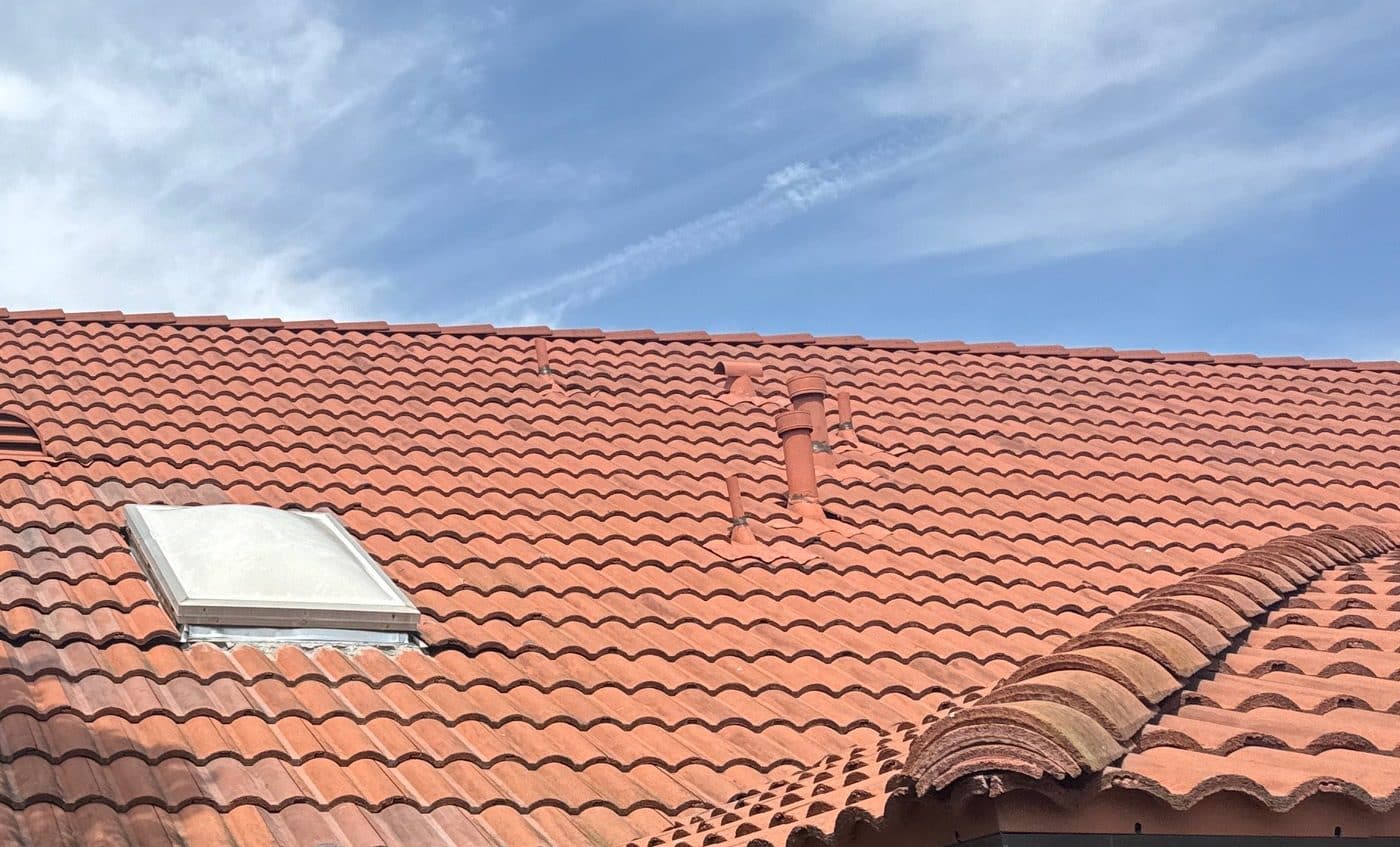 clay barrel tile roof with skylight and plumbing vent pipes — Roof Replacement Inc