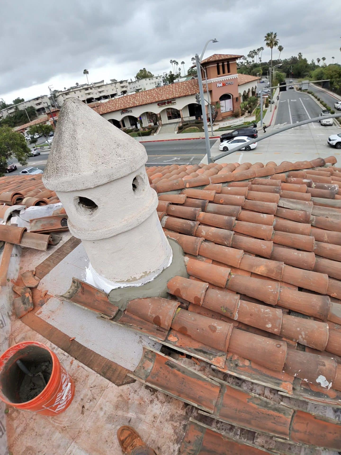 Clay barrel tile roof with decorative cement chimney cap being installed | Roof Replacement Inc Clay barrel tile roof with decorative cement chimney cap being installed — Roof Replacement Inc