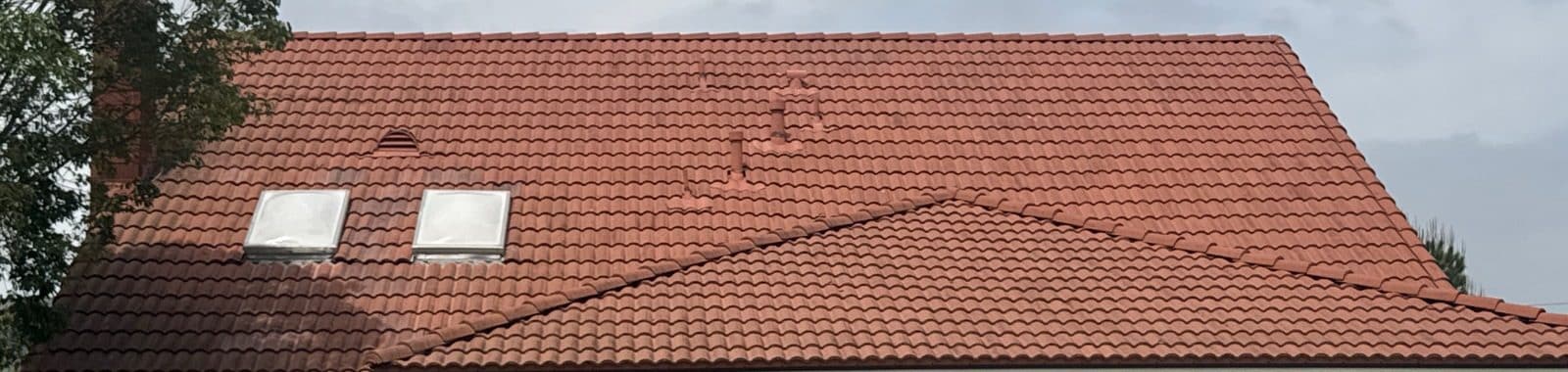 Red clay tile roof with two skylights and damaged ridge tiles — Roof Replacement Inc