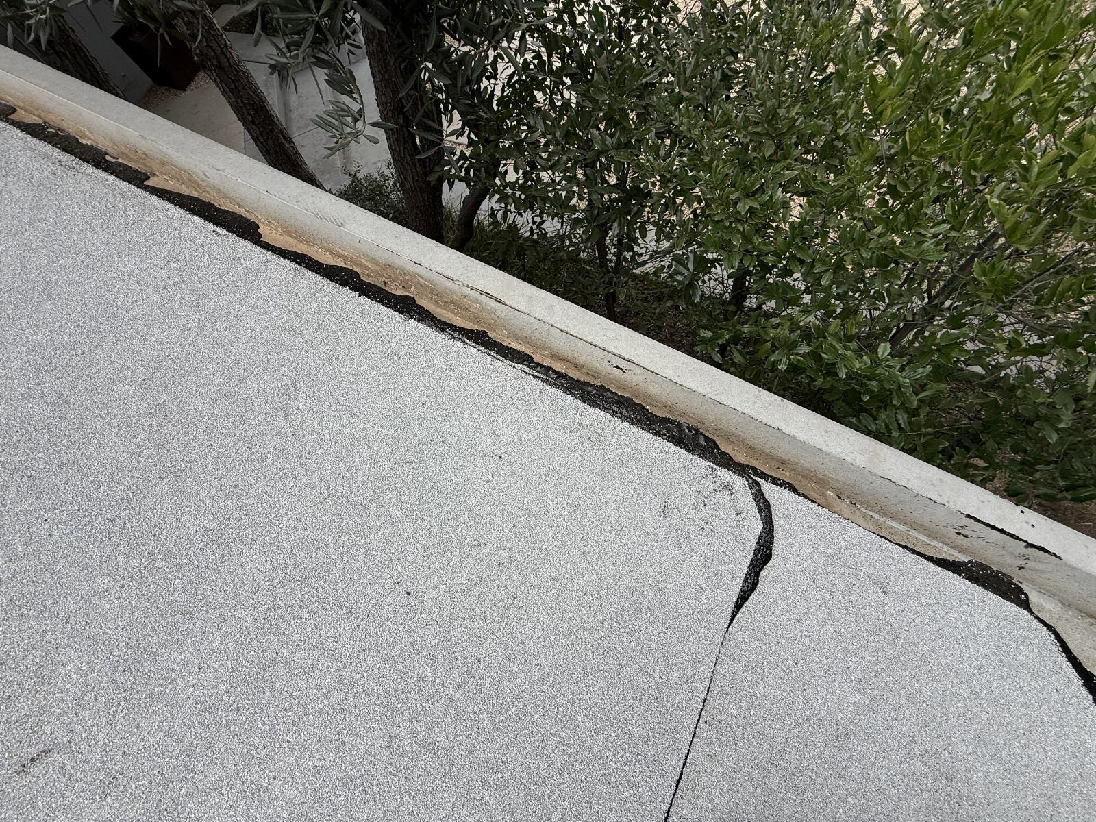 cracked flat roof membrane peeling away from concrete parapet edge — Roof Replacement Inc