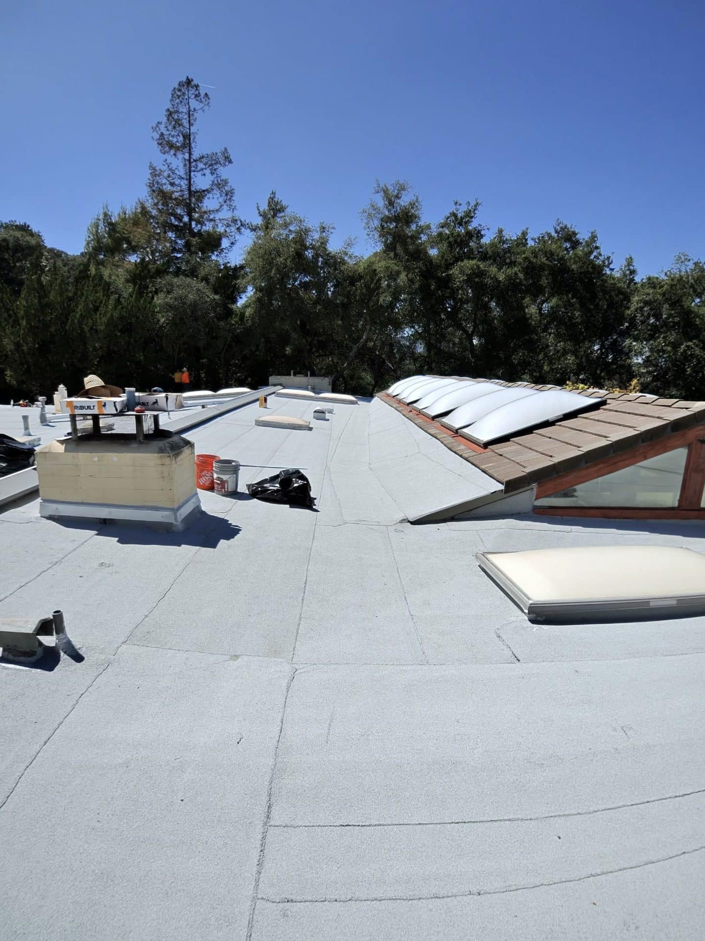 flat roof with modified bitumen membrane skylights chimney and workers — La Cañada Flintridge — Roof Replacement Inc