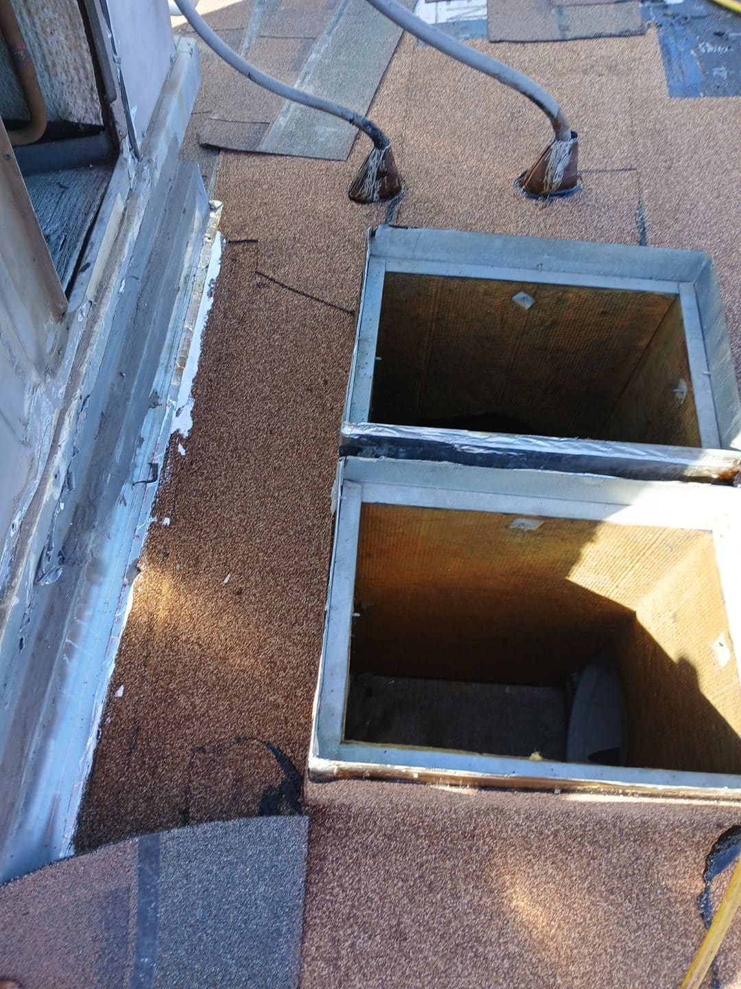 Flat roof with two open skylight curbs, rolled roofing, conduit penetrations | Roof Replacement Inc Flat roof with two open skylight curbs, rolled roofing, conduit penetrations — Roof Replacement Inc