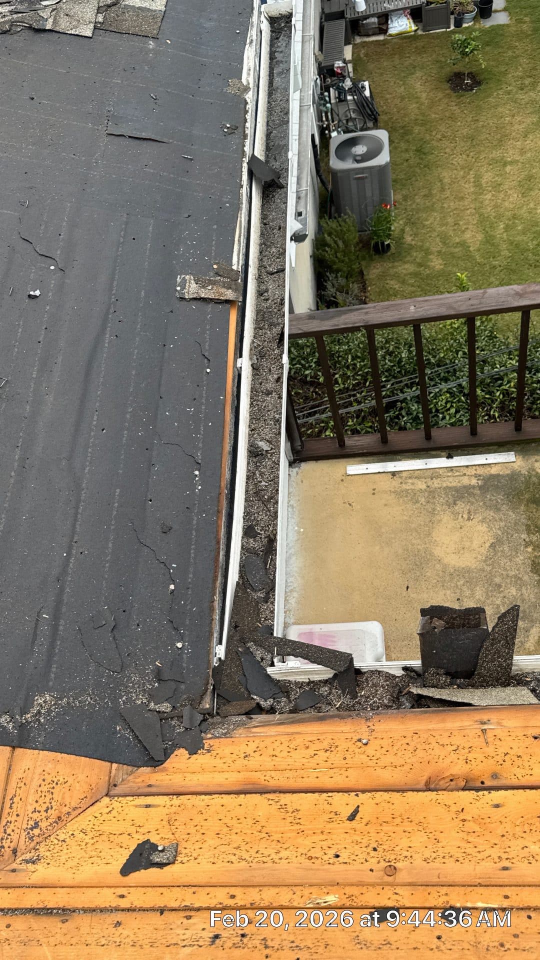 Flat roof tear-off exposing underlayment, debris in gutter and on deck below | Roof Replacement Inc Flat roof tear-off exposing underlayment, debris in gutter and on deck below — Roof Replacement Inc