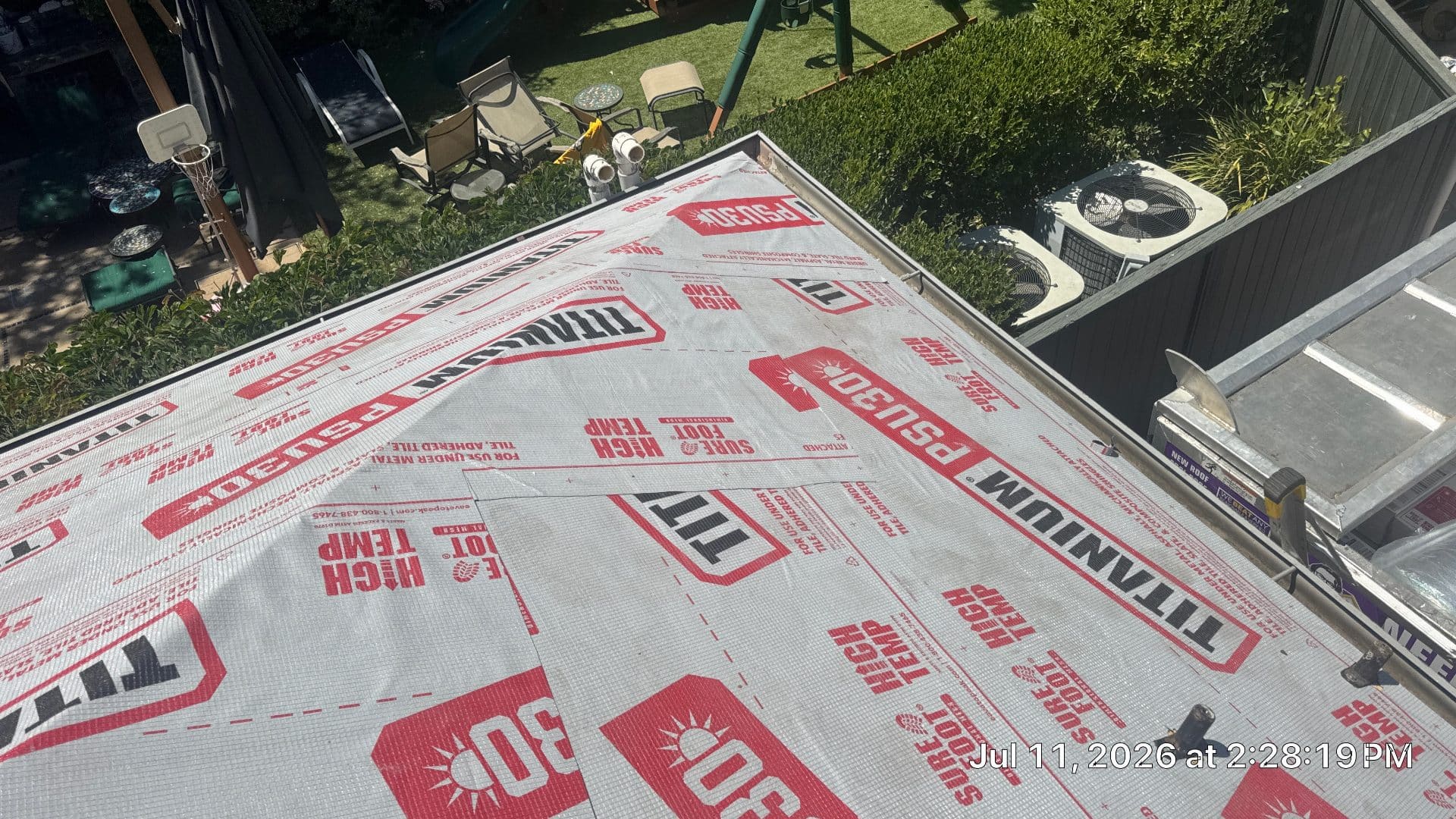 Flat roof deck covered with Titanium PSU30 high-temp underlayment, ladder visible | Roof Replacement Inc Flat roof deck covered with Titanium PSU30 high-temp underlayment, ladder visible — Roof Replacement Inc