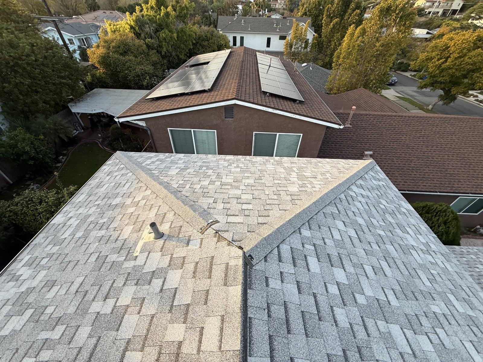 Gray asphalt shingle hip roof with pipe vent and valley — Roof Replacement Inc