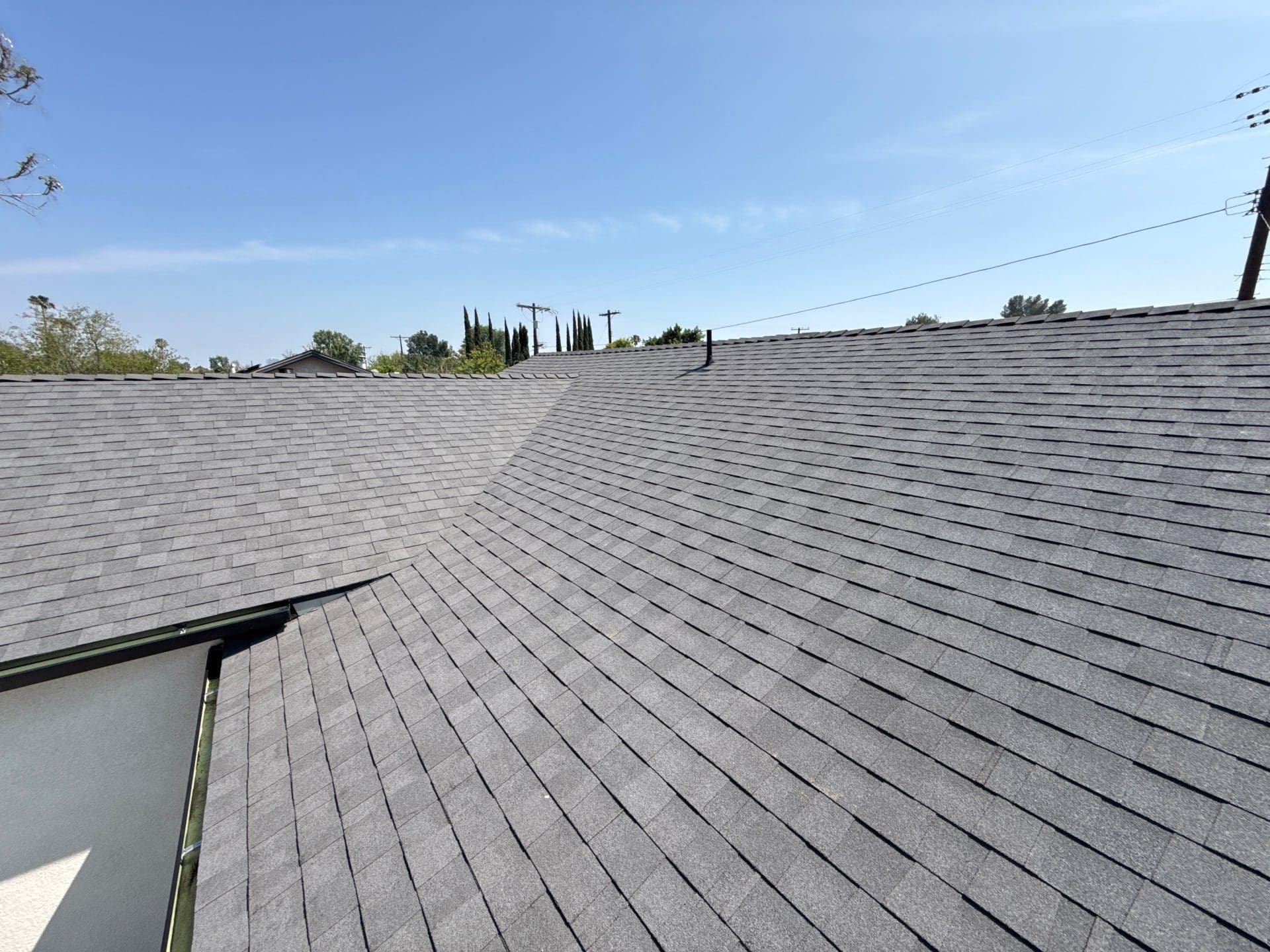 Gray asphalt shingle roof with hip valley and gutters — Roof Replacement Inc