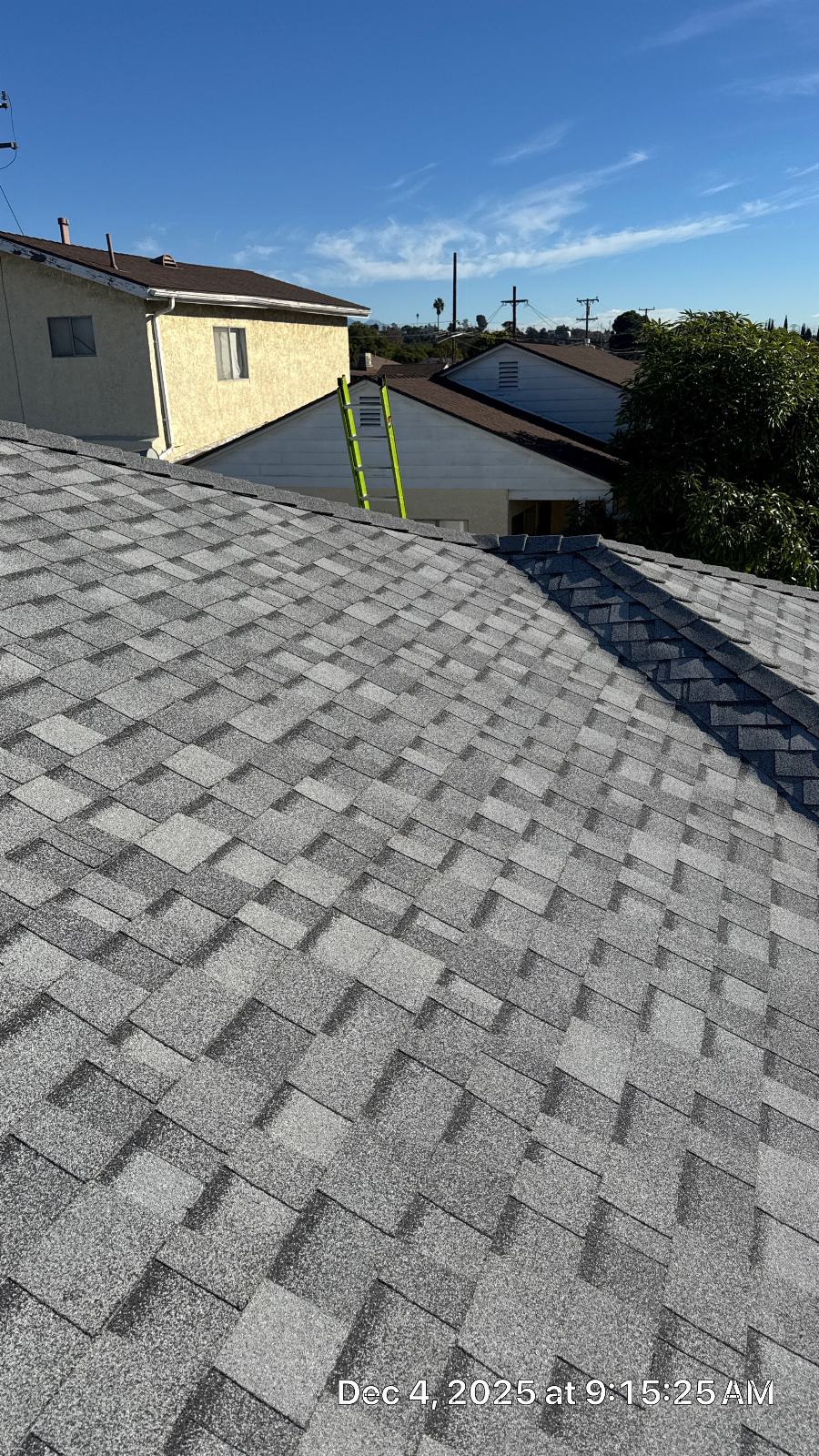 New gray asphalt shingle roof with hip ridge, green ladder visible | Roof Replacement Inc New gray asphalt shingle roof with hip ridge, green ladder visible — Roof Replacement Inc